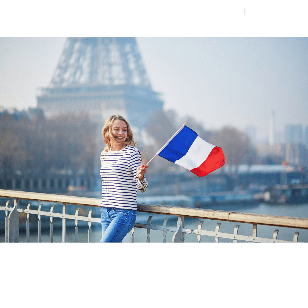 Person waving the French flag with the Eiffel tower in the back ground.