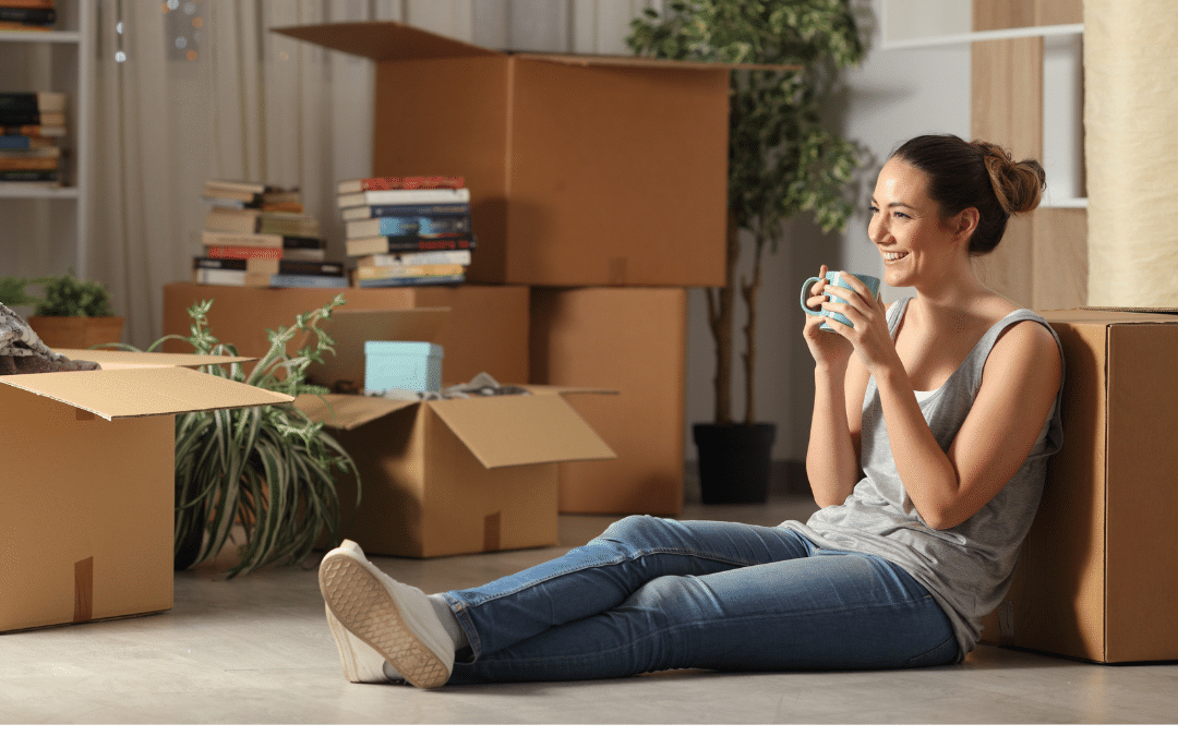 Woman moving into her home, surrounded by moving boxes